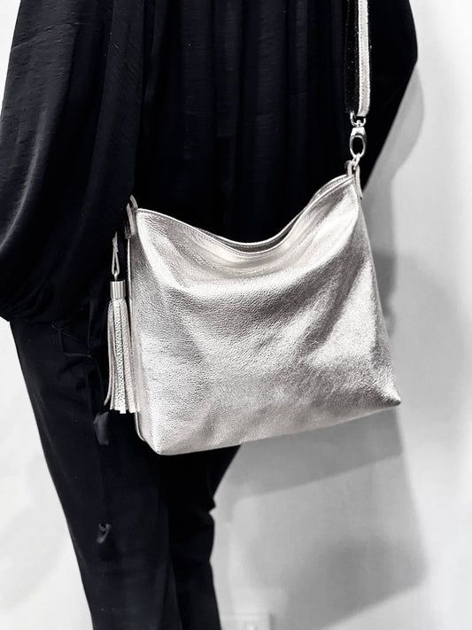 model showing Silver handbag worn crossbody adjustable and worn day or night