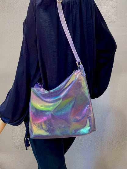 Holographic metallic leather bag worn by a person on the shoulder with top zipper closure