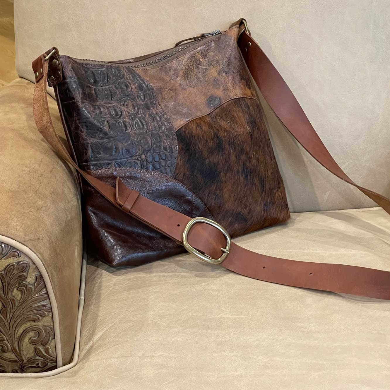 Multi Brown leathers patchwork handbag with cowhide and tooled patterns on a leather chair strong strap buckle.