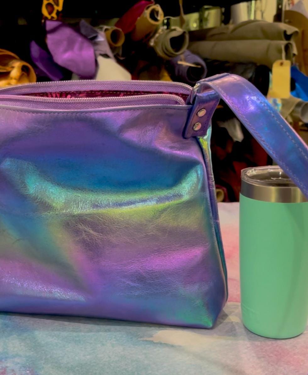 Iridescent colourful bag next to a mint green tumbler for sizing 