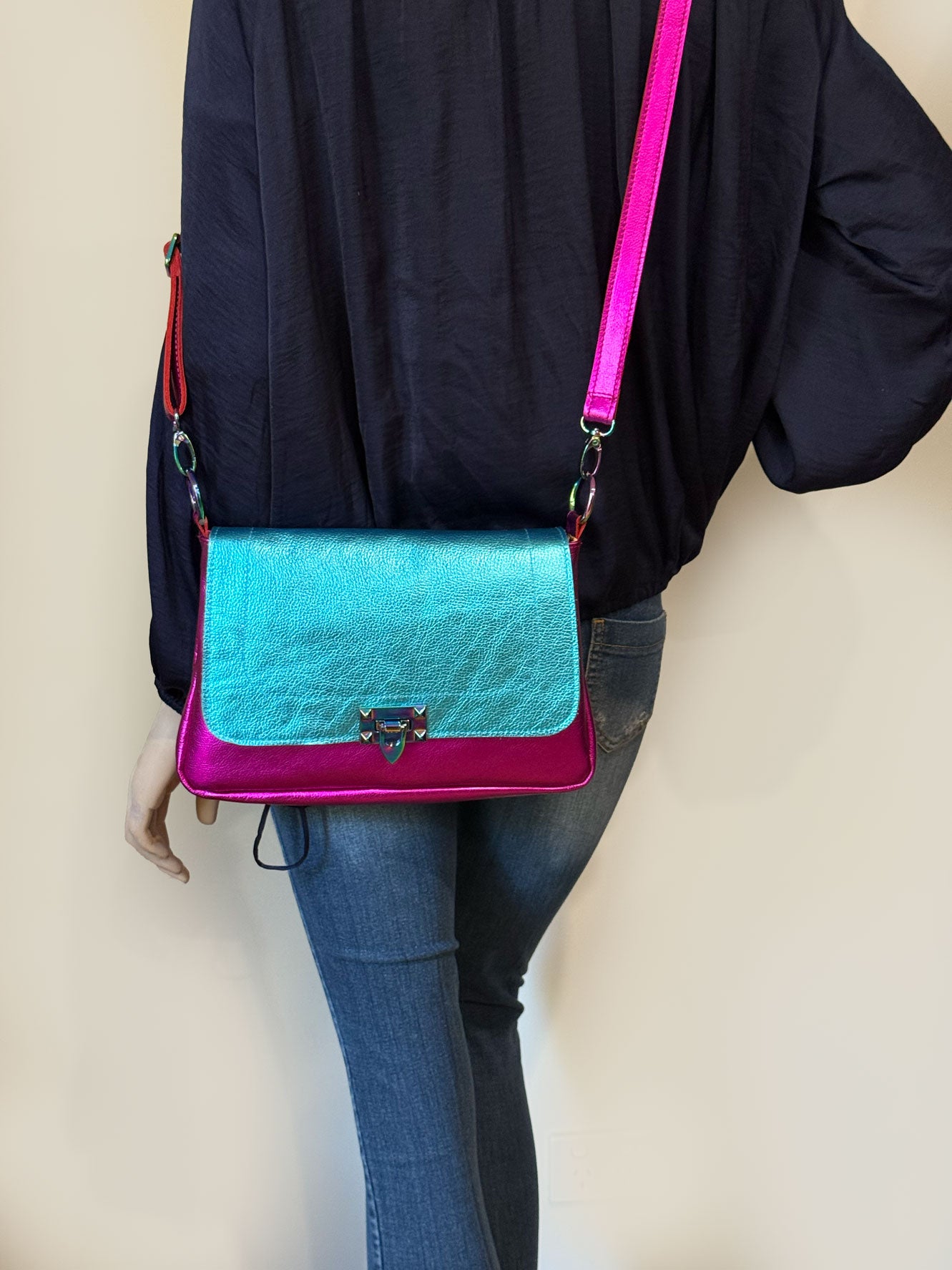 full length Person wearing a blue and pink metallic leather handbag crossbody with removable strap on O rings. great for day and evening bag