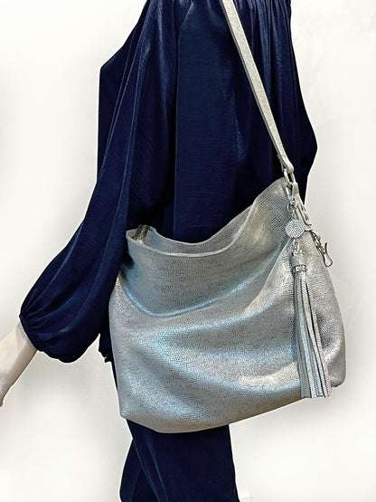 Silver handbag with a tassel charm on model