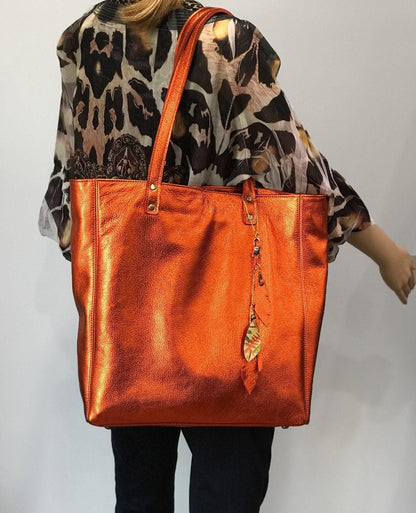 Soft Metallic warm orange leather Tote with strong lining. protective feet and padding. leather zipper pocket and key clasp. Large size on model