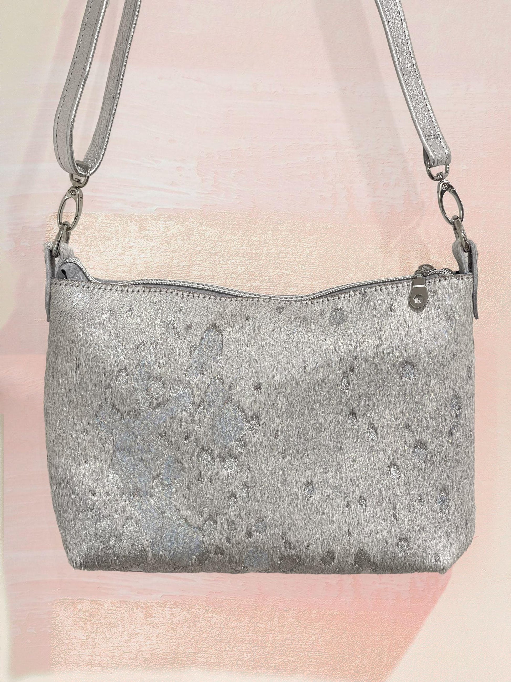 Silver iridescent textured handbag on a pink and white gradient background