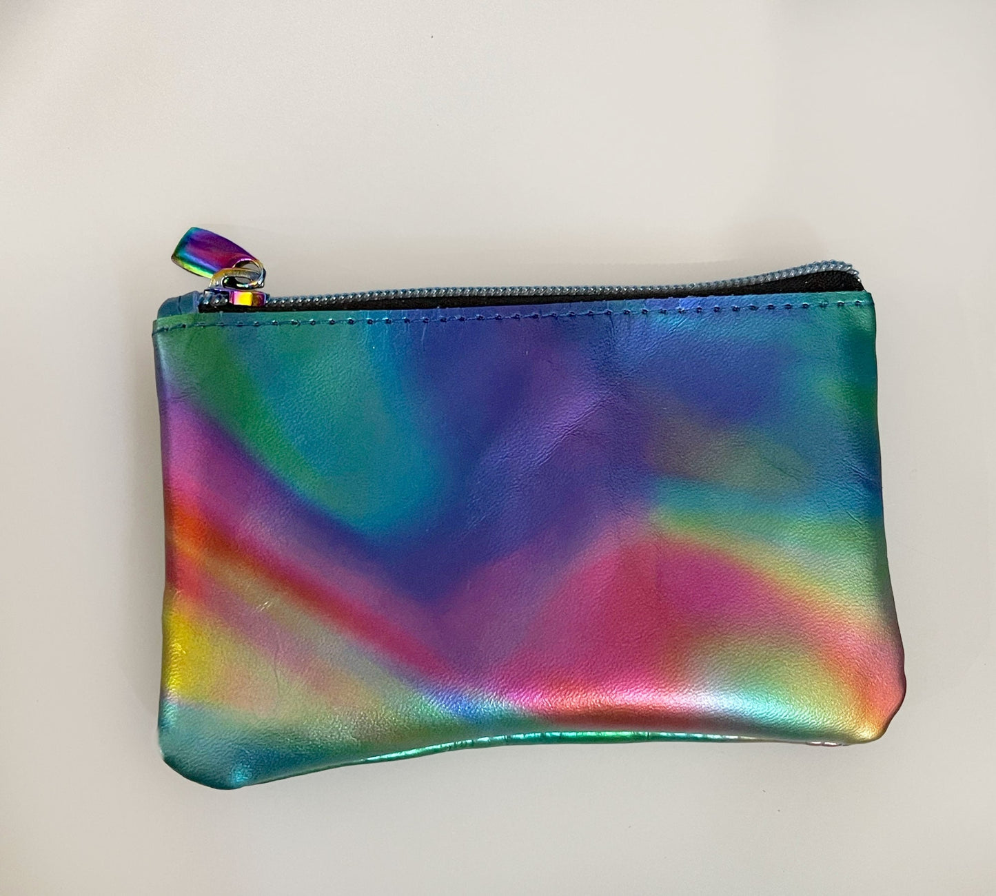 Multicolored iridescent pouch with a zipper on a light gray background