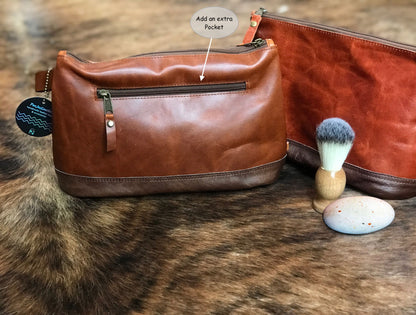 Brown leather dopp kit with shaving brush and additional pocket feature on a fur surface.
