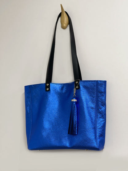 Blue metallic tote bag with a tassel on a light gray background