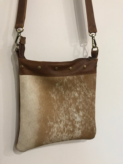 Brown leather and cowhide patterned bag on a white background
