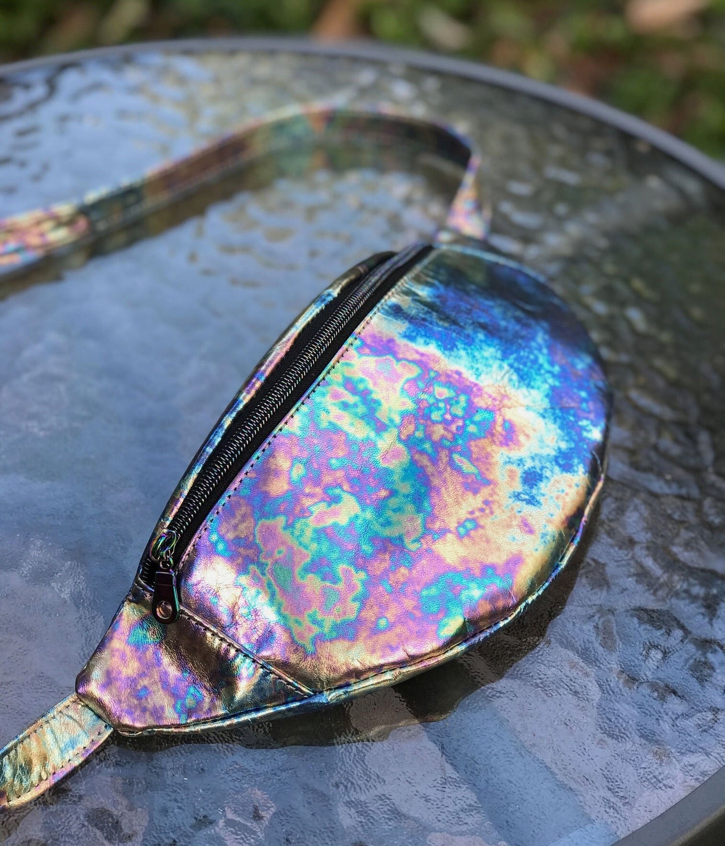 Iridescent tie dye leather fanny pack outside sunlit reflection
