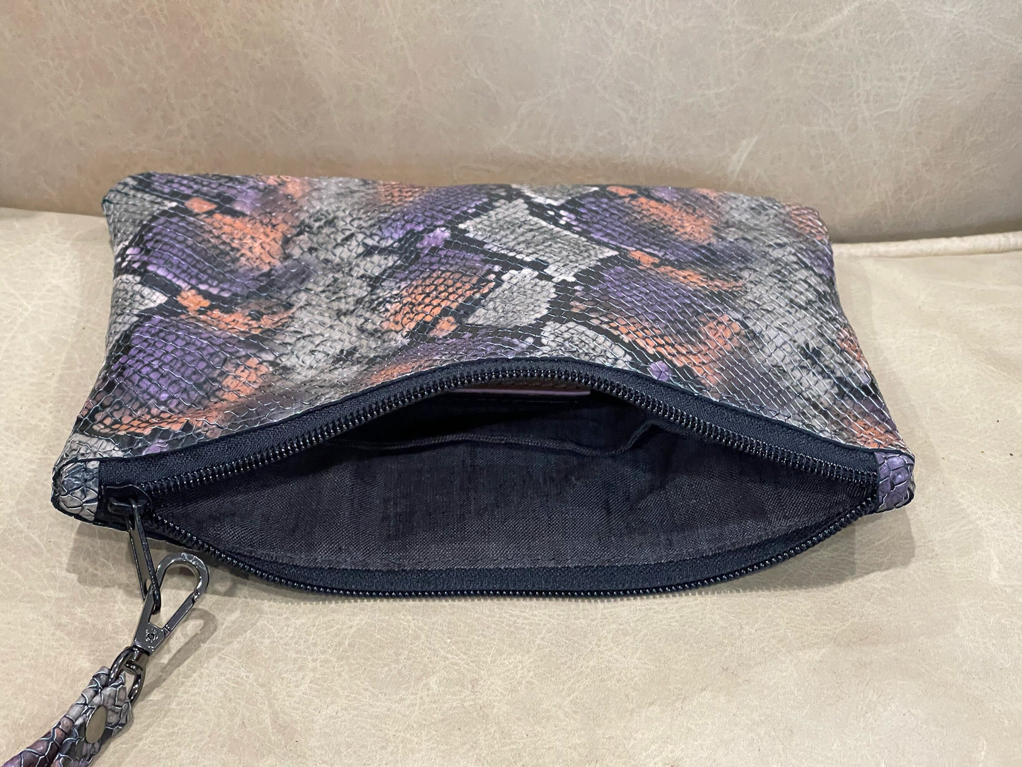 realistic snakeskin embossed patterned pouch with a zipper closure and removable wristlet strap