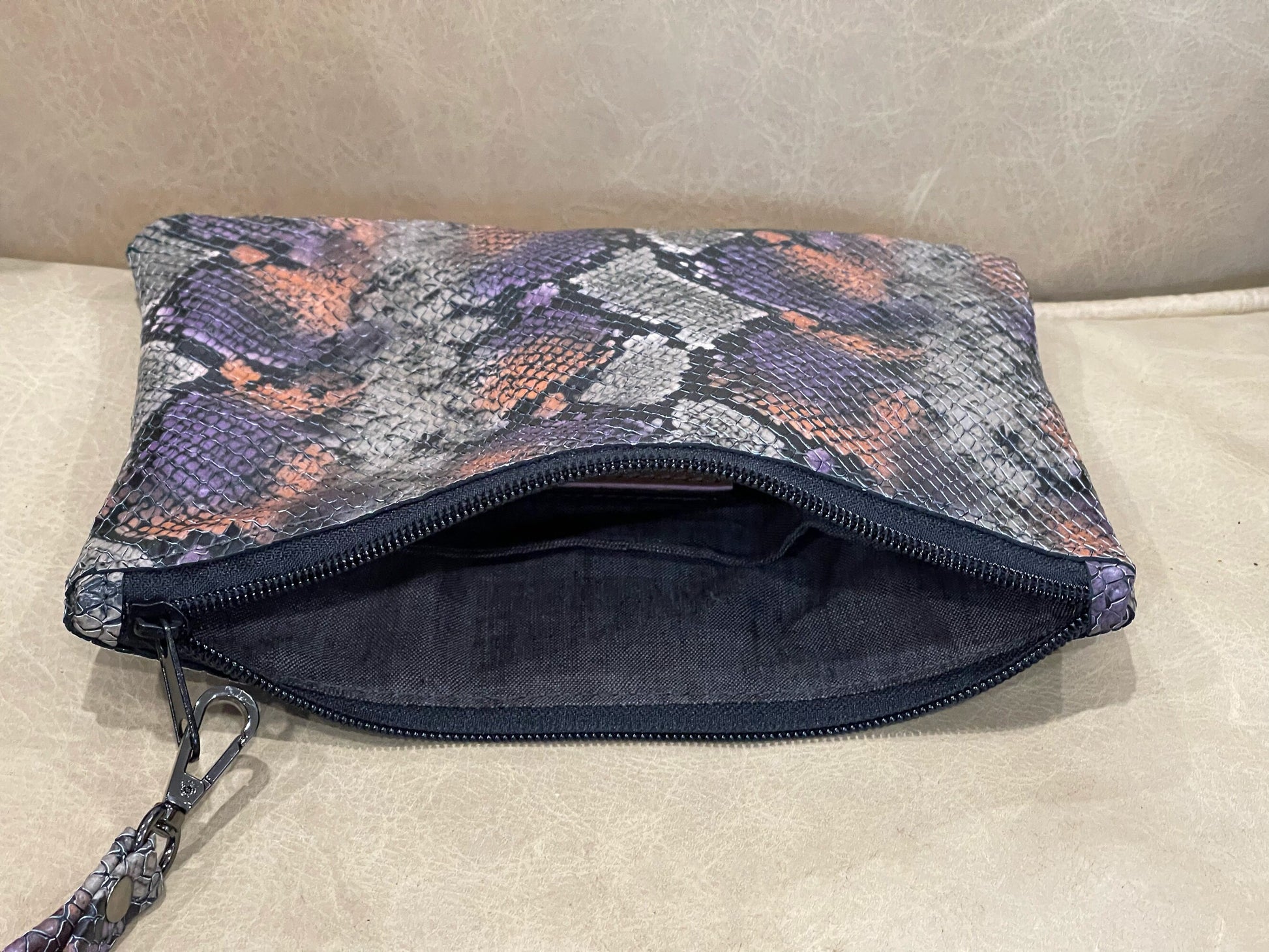 realistic snakeskin embossed patterned pouch with a zipper closure and removable wristlet strap