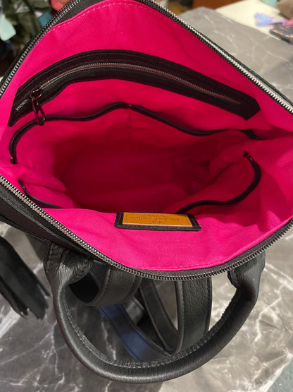 backpack showing inside lining of hot pink and zipper pocket and multiple slip pockets