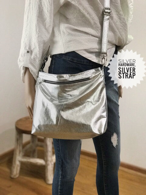 Person wearing a silver crossbody bag with 'Slver Hardware Silver Strap. with outside zipper pocket for easy access