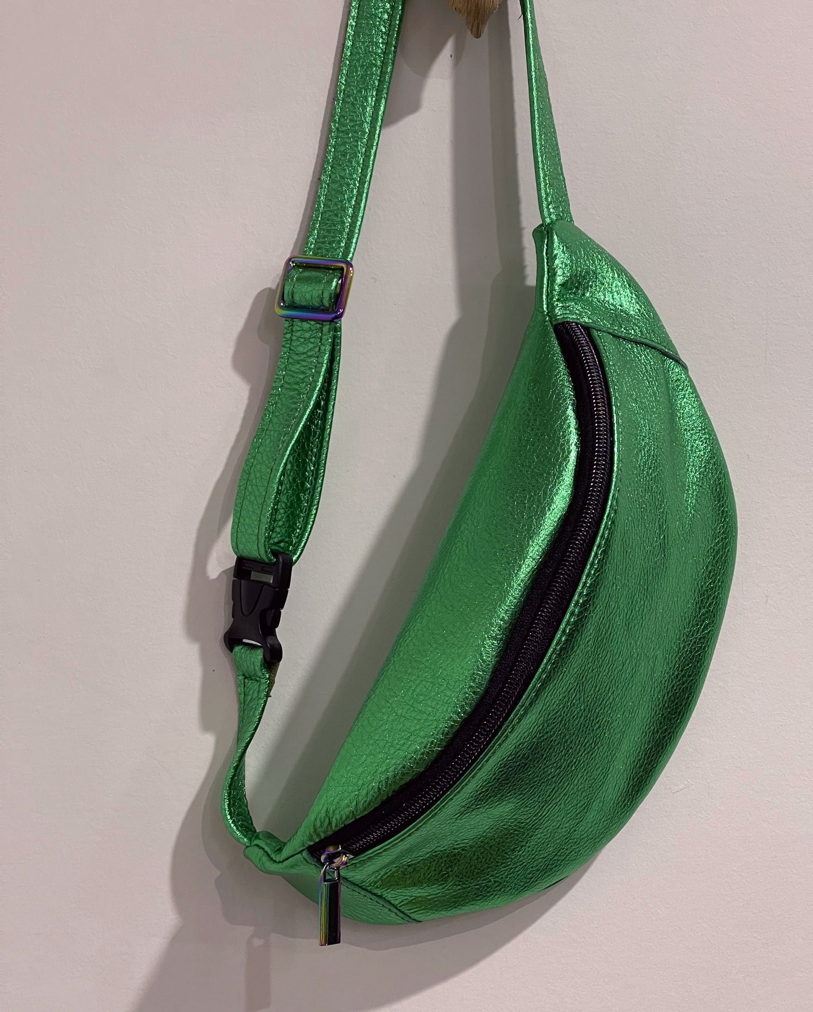 Green metallic fanny pack on a light gray background