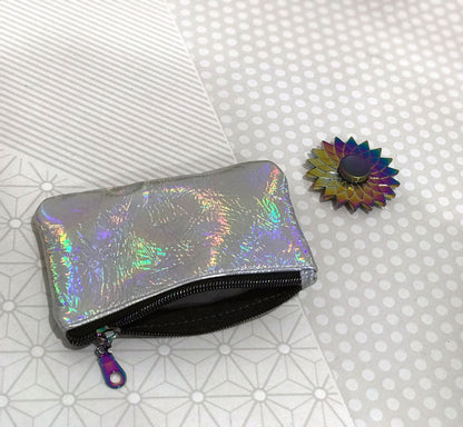 Holographic pouch and colorful flower-shaped object on a patterned surface