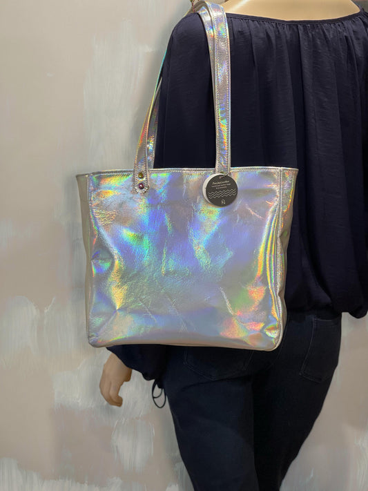Holographic tote worn on a persons shoulder with large gap in straps for arms against a neutral background