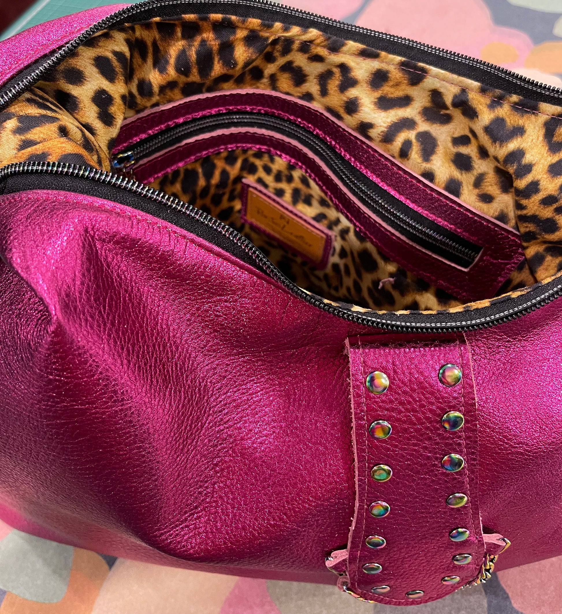 Pink metallic leather handbag with leopard print interior and zipper pocket