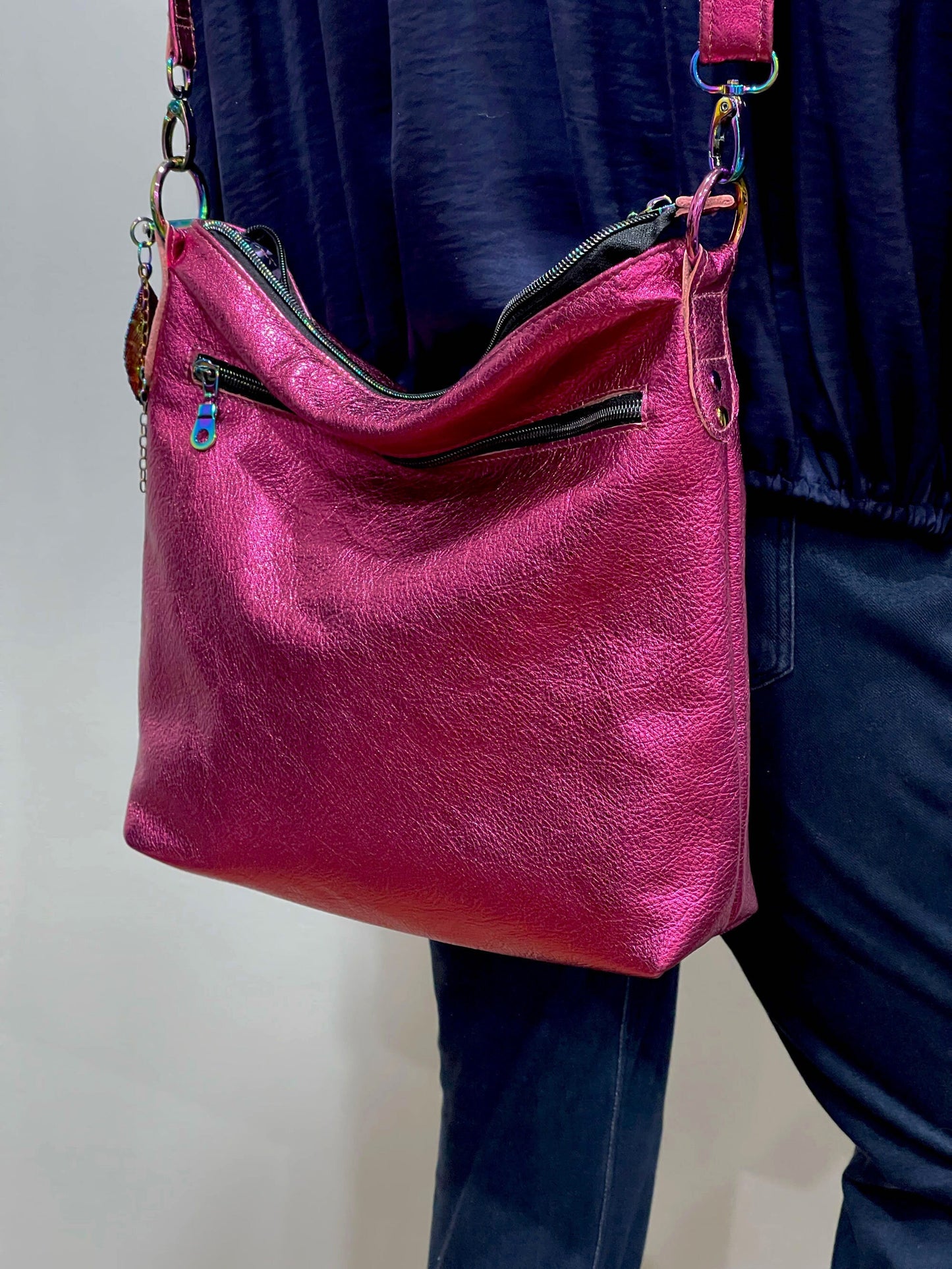 Pink leather handbag worn over shoulder against a neutral background
