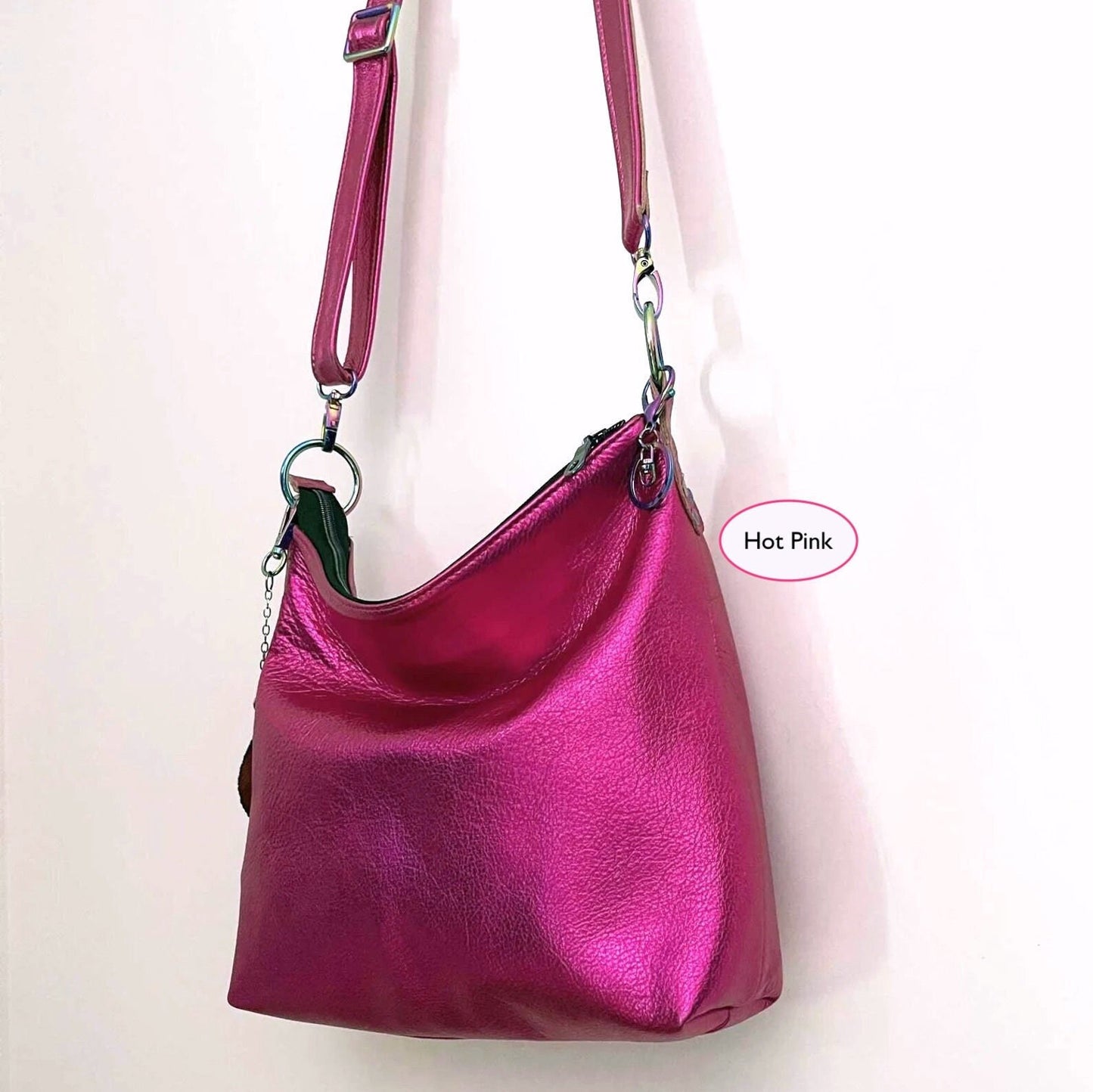 front side view of Hot pink handbag with a removable and adjustable strap on a white background