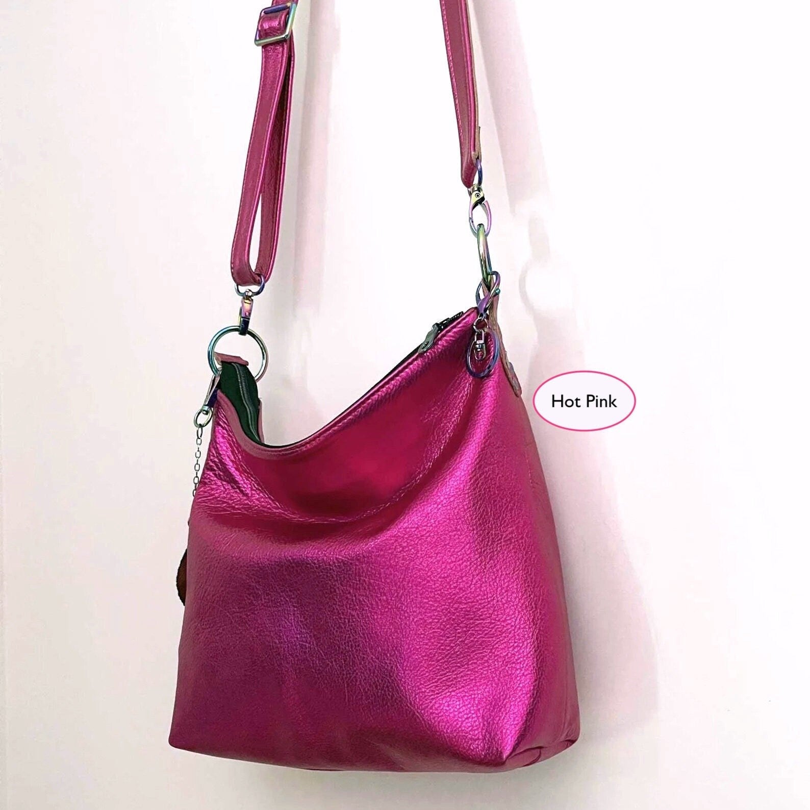 front side view of Hot pink handbag with a removable and adjustable strap on a white background