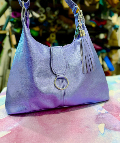 lavender Purple handbag with a tassel on a colorful surface