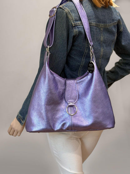 Purple handbag worn by a person against a neutral background