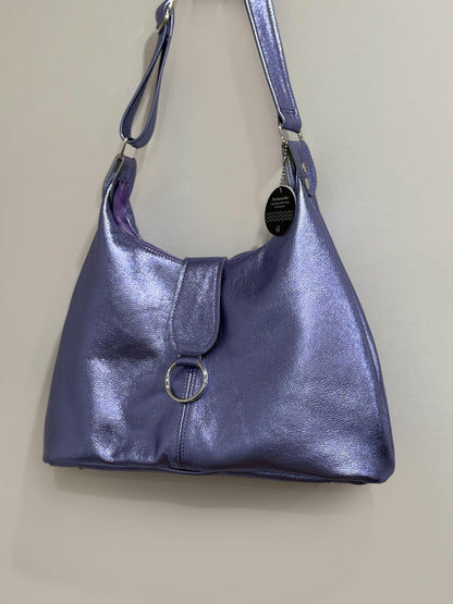 lilac Purple metallic leather handbag with a strap on a beige background
