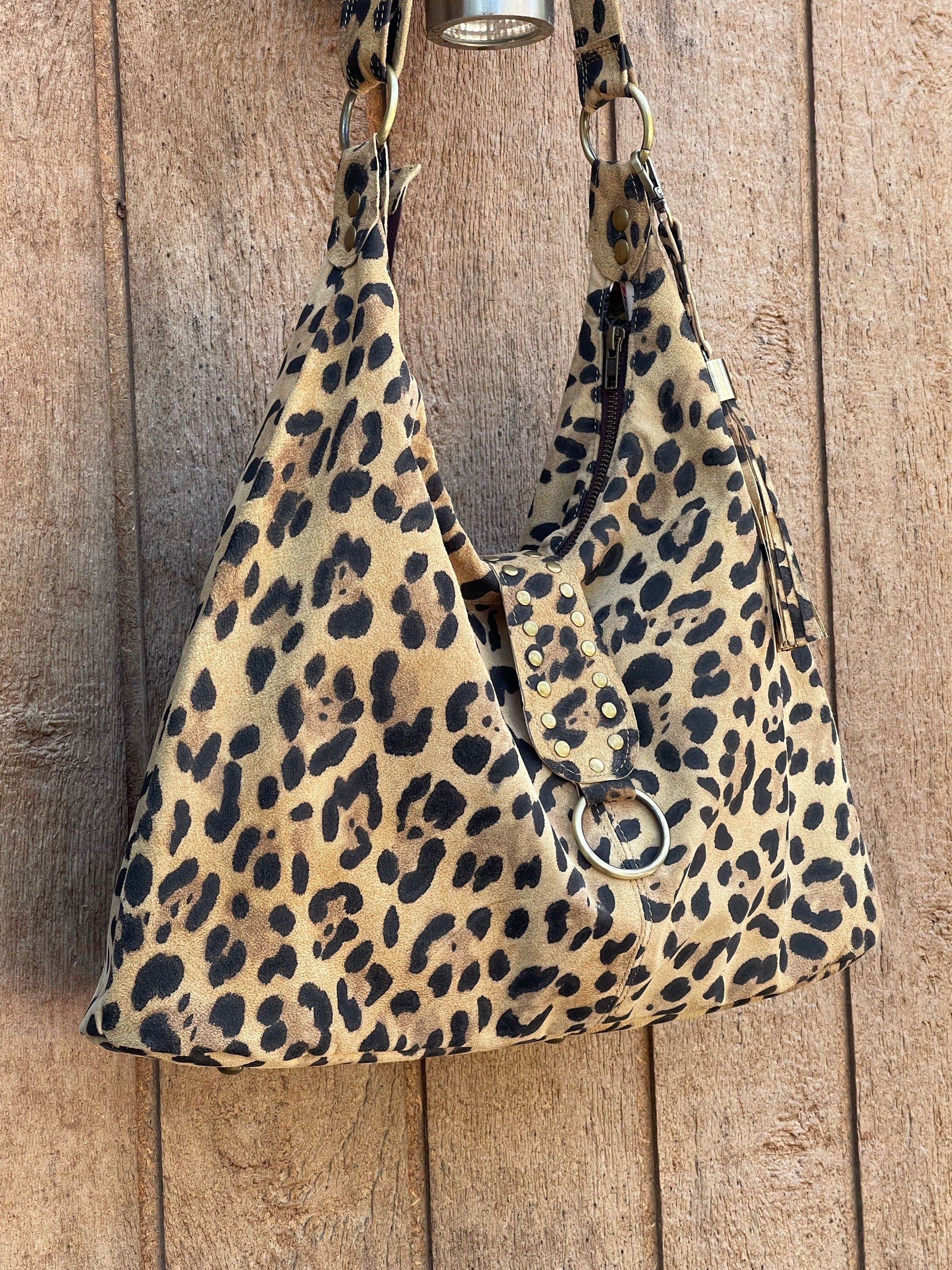 side view of Leopard print suede hobo handbag hanging on a wooden surface