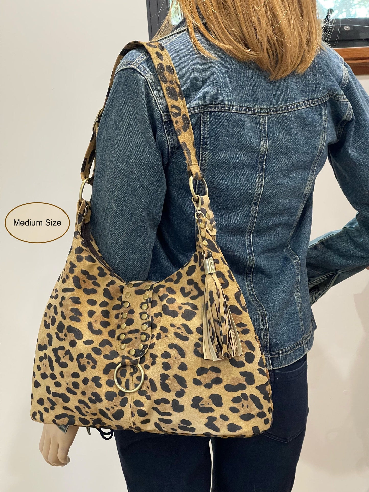 Person wearing a leopard print bag with a denim jacket