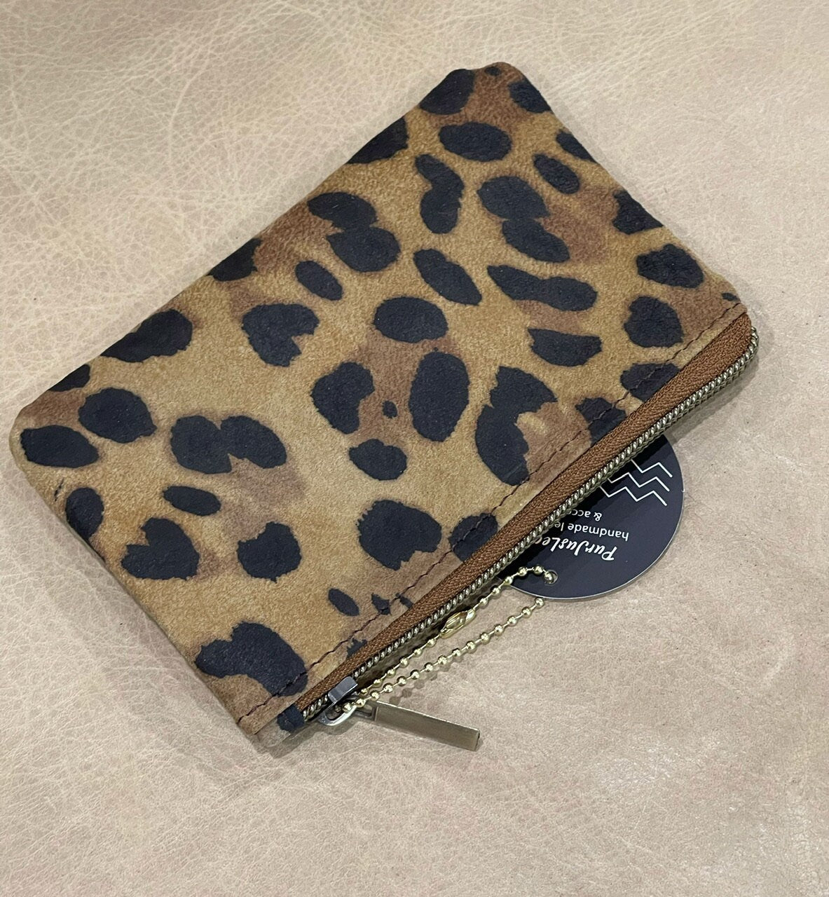 Leopard print wallet on a beige surface