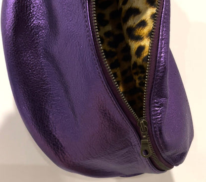 close up of Purple leather fanny pack with a leopard print interior on a white background