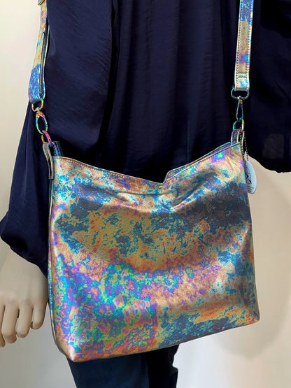 oil slick petrol pattern multi coloured handbag with a person wearing a dark blue silk shirt