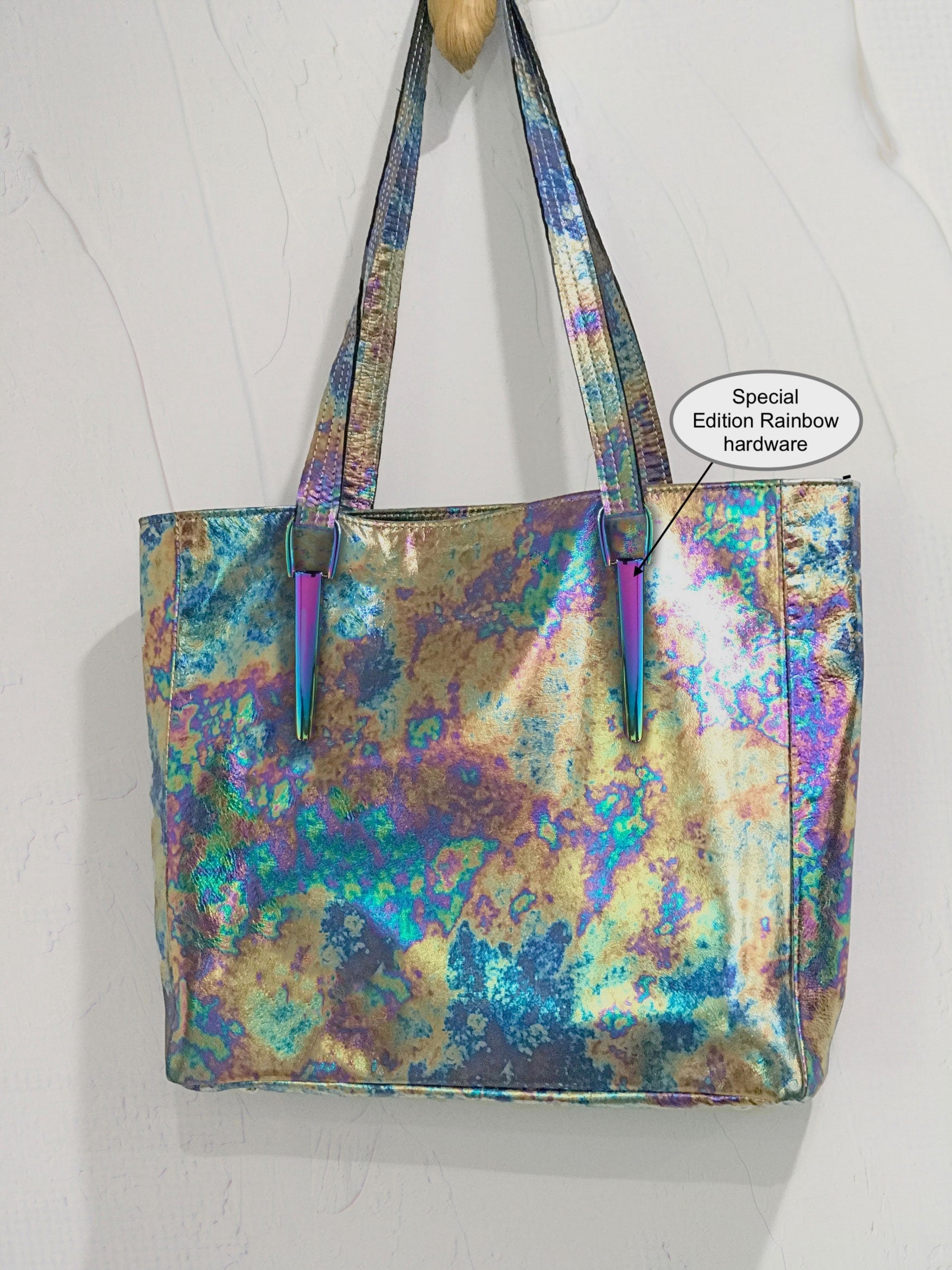 Iridescent tote bag with rainbow hardware on a white background