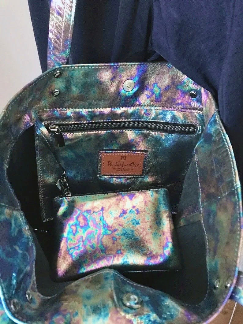 Multicolored iridescent handbag opened to show the space and zipper pocket and zipper purse