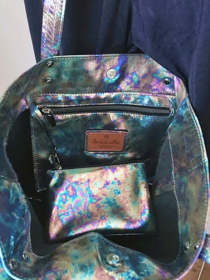 Multicolored iridescent handbag opened to show the space and zipper pocket and zipper purse