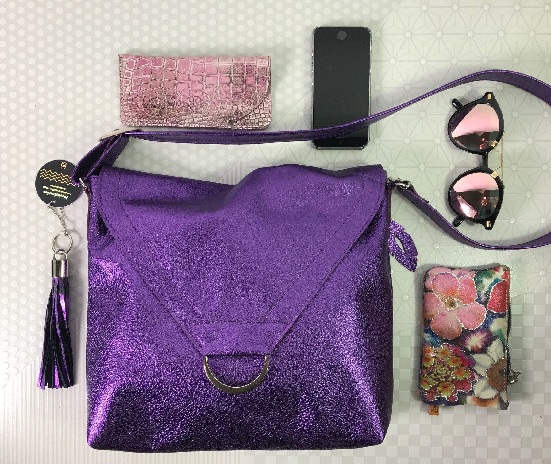 Purple handbag with some accessories including a phone, wallet, and sunglasses that fit easily into the spacious bag