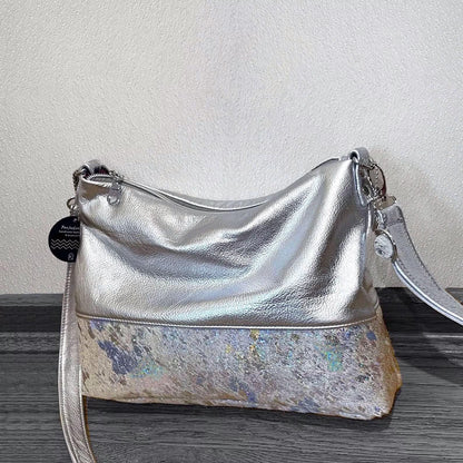 Silver handbag with acid wash holo cowhide on a wooden surface
