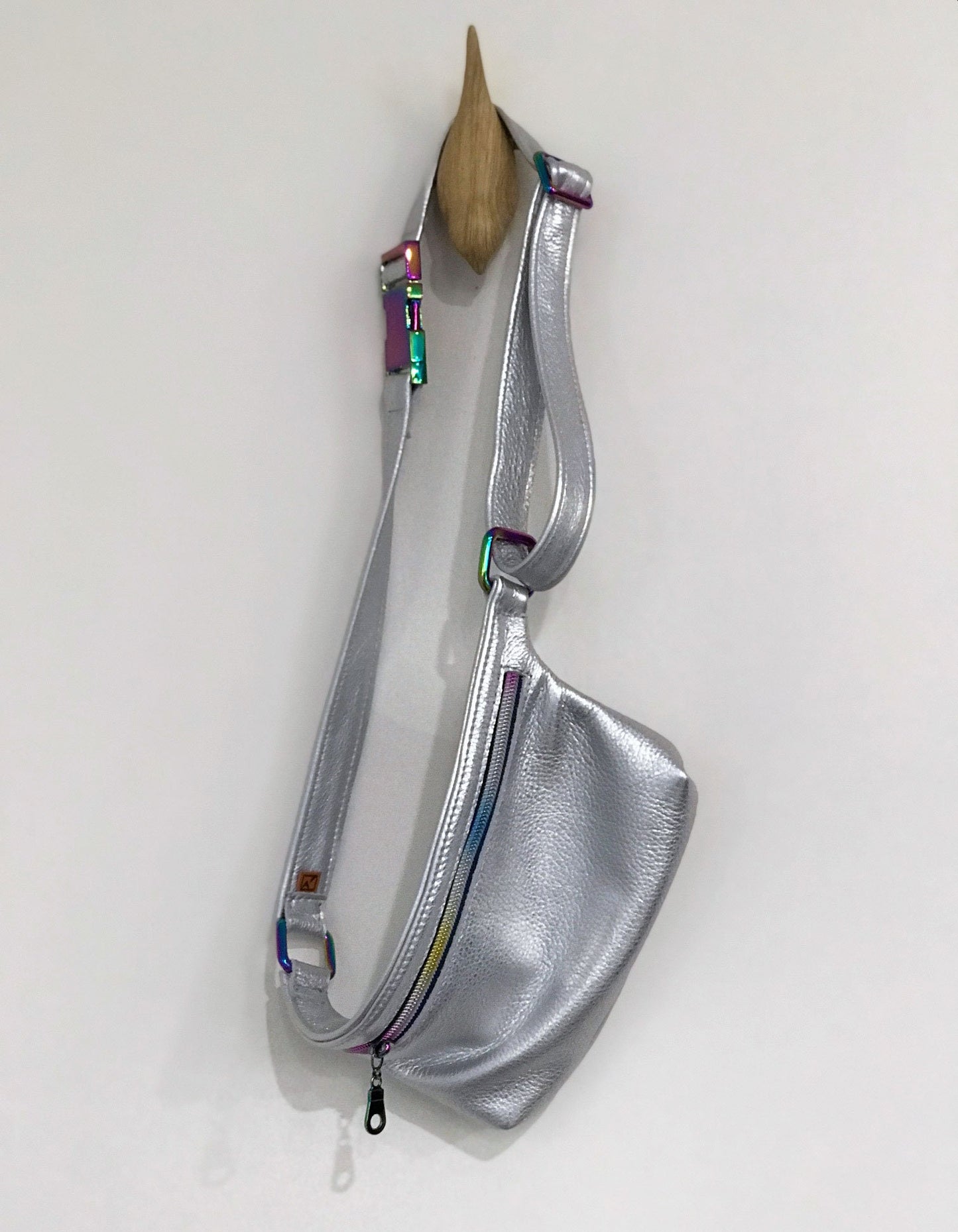 Silver sling bag with colorful accents on a white background