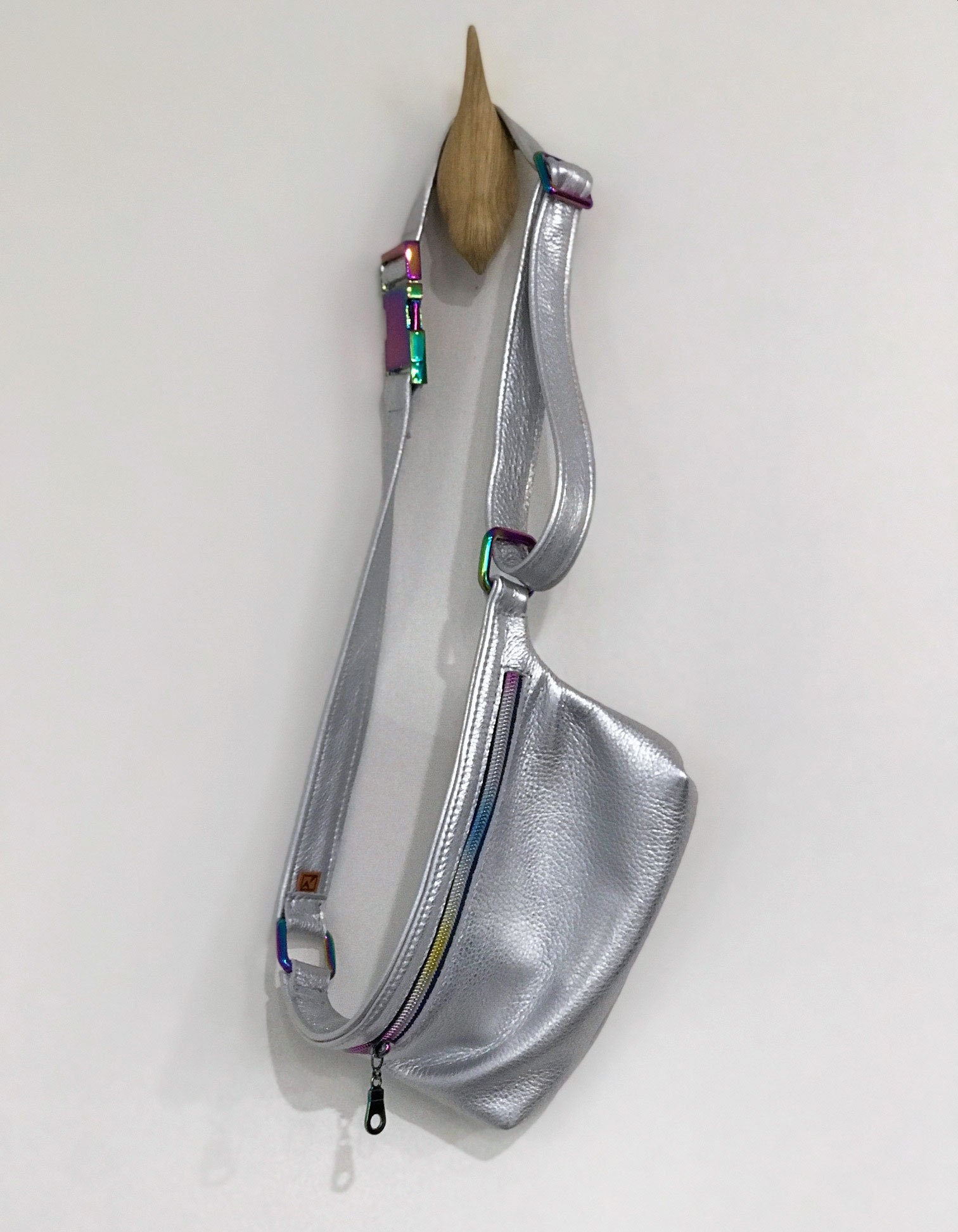 Silver sling bag with colorful accents on a white background