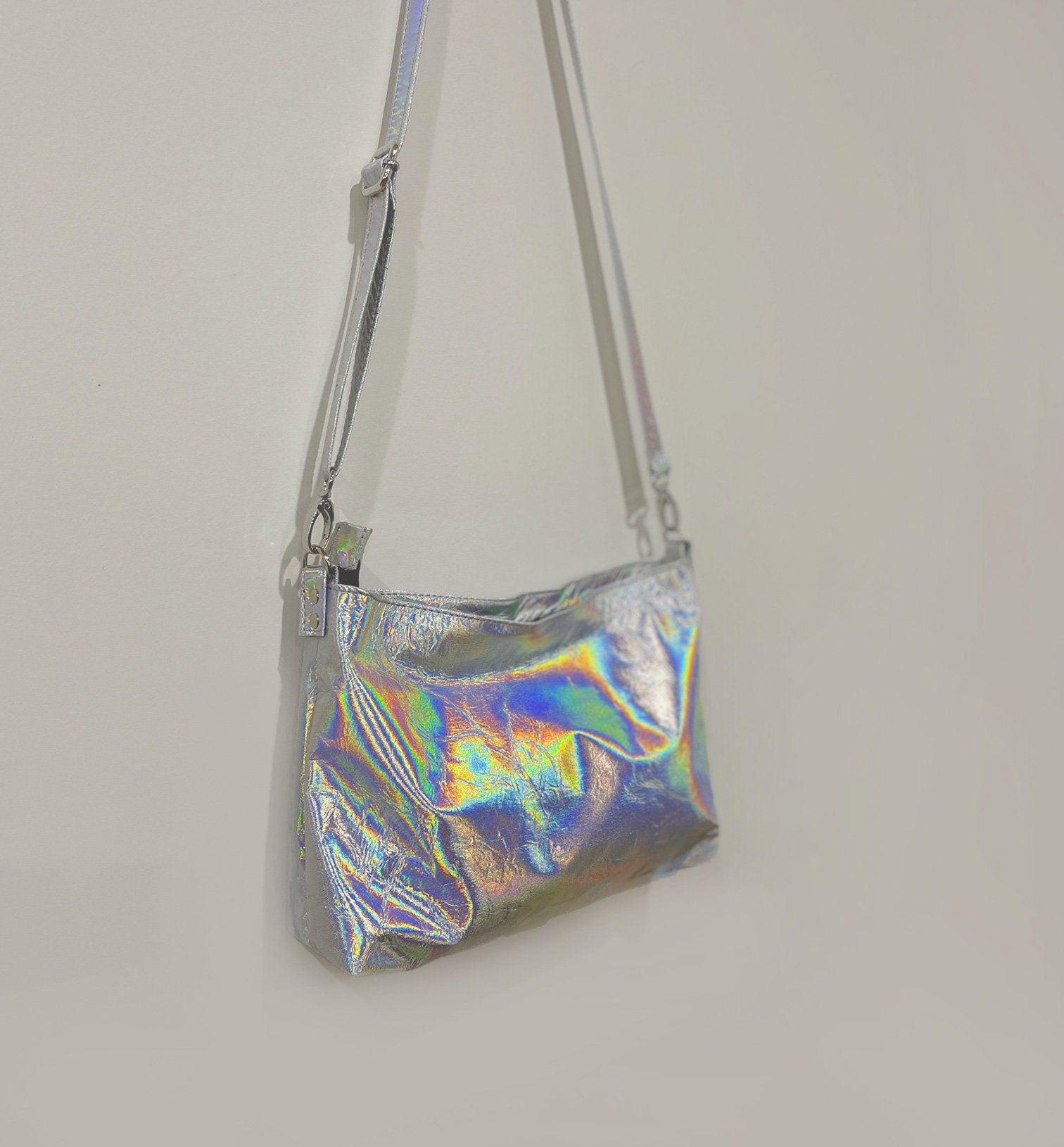 Holographic silver handbag on a plain background