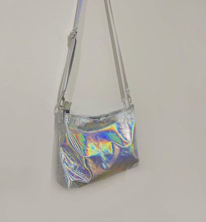 Holographic silver handbag on a plain background