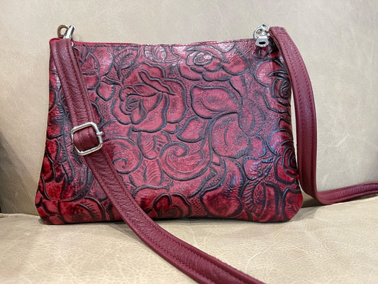 close up of Red leather handbag with floral embossin
