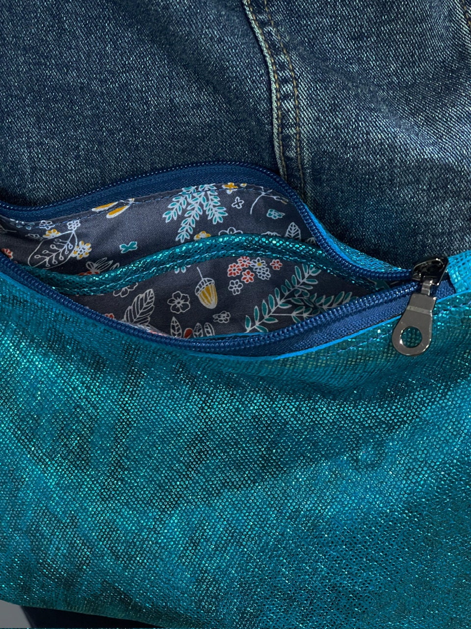 Close-up of a aqua teal bag with a floral lining.
