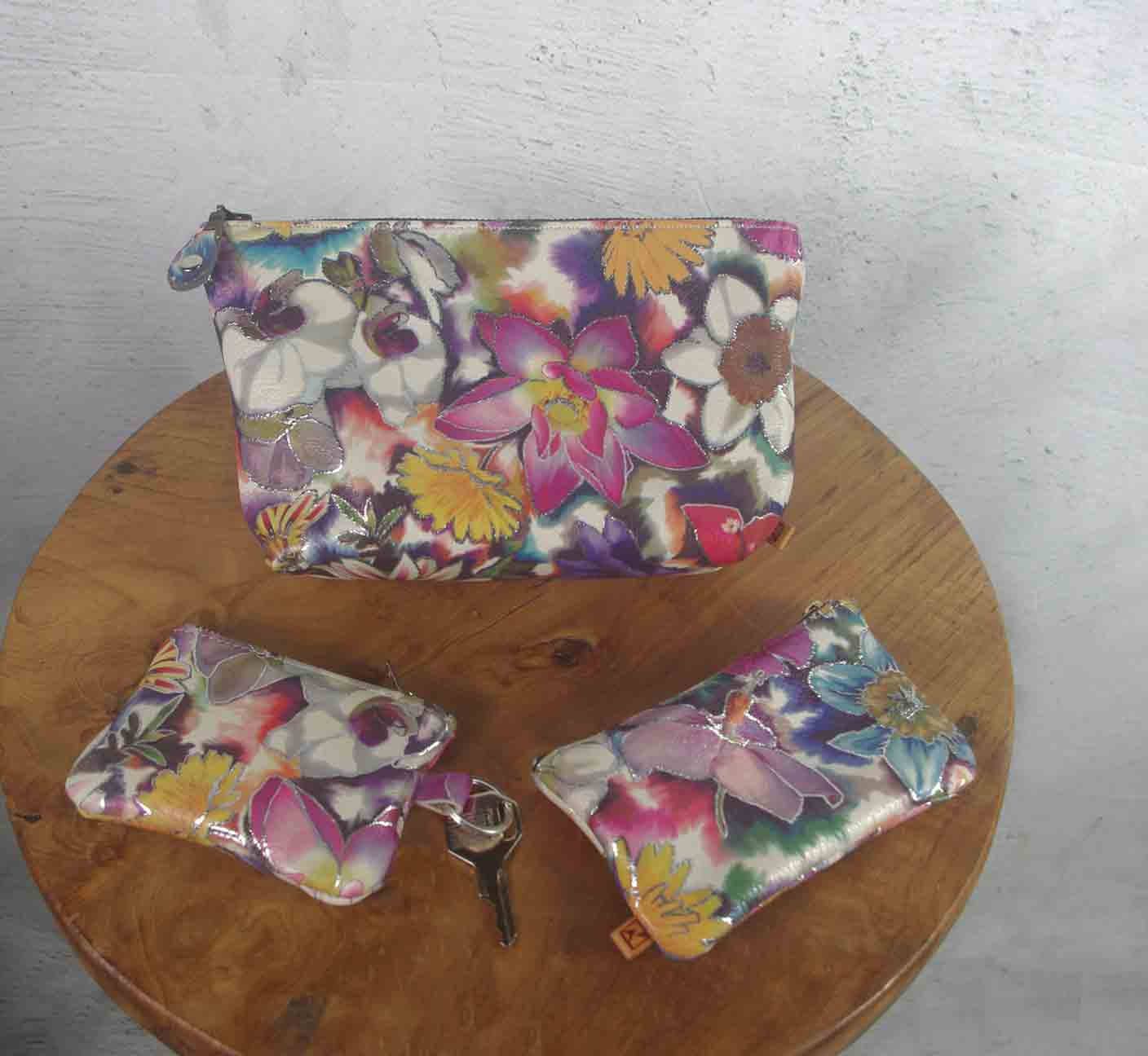 Floral-patterned pouches on a wooden surface with keys.