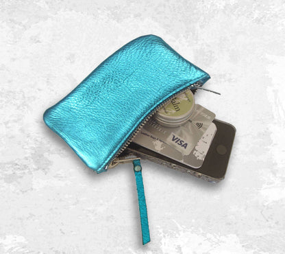 Turquoise wallet with small phone, cards, and money inside